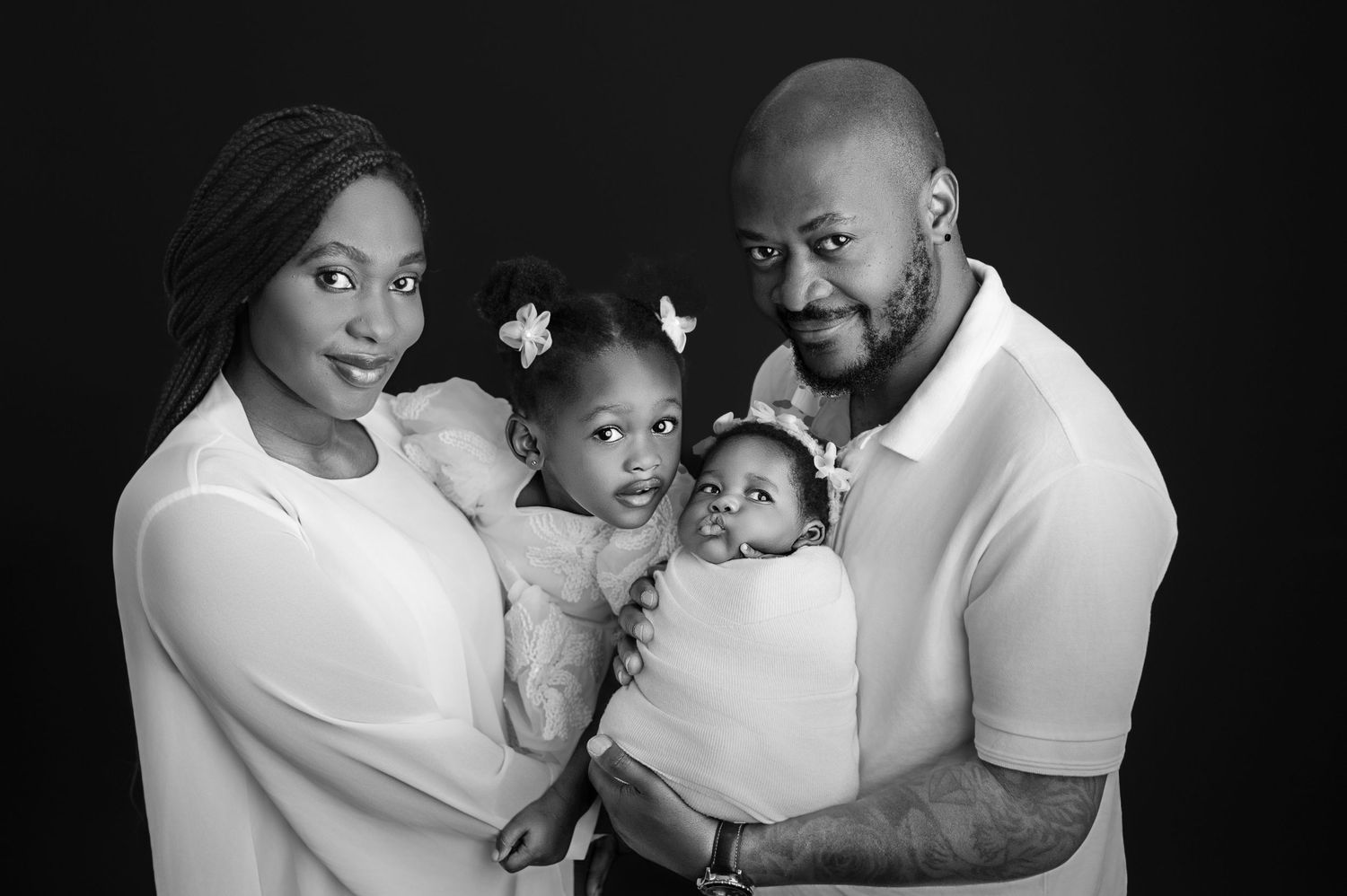A series of black and white family photos showing tender moments between parents and their baby.