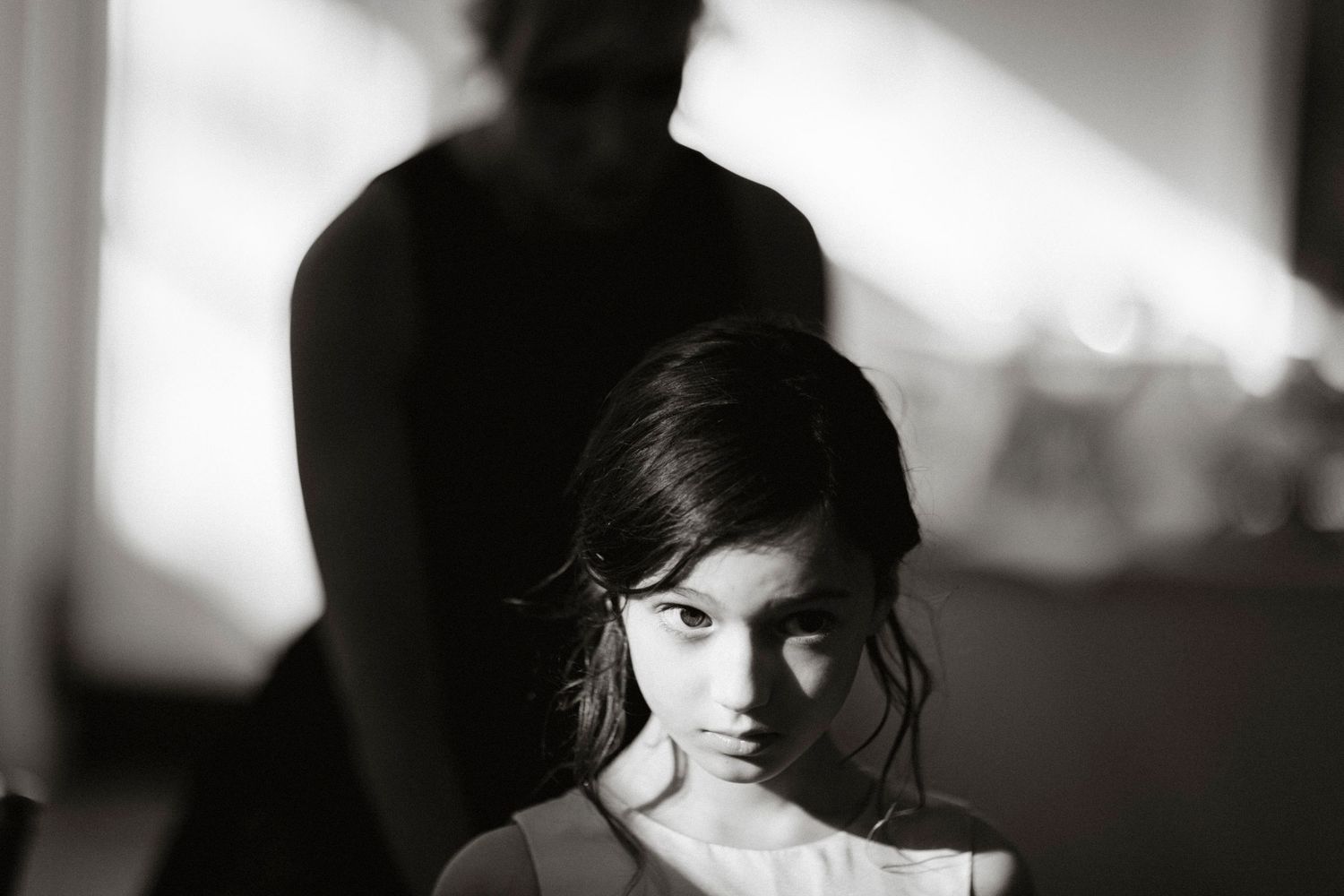 A dramatic black and white photo series showing a person's silhouette and profile against contrasting light backgrounds.
