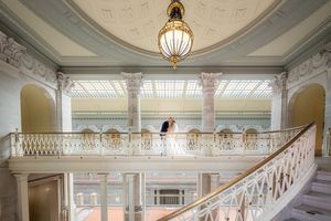 Elegant white marble staircase with ornate railings and architectural details in a grand historic building interior.