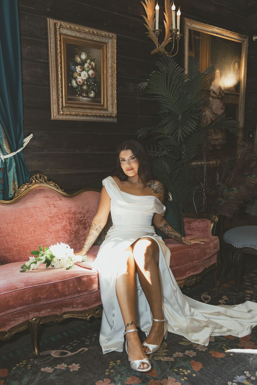 A series of four photos showing someone in a white wedding dress sitting on an elegant vintage pink couch in a dimly lit room.