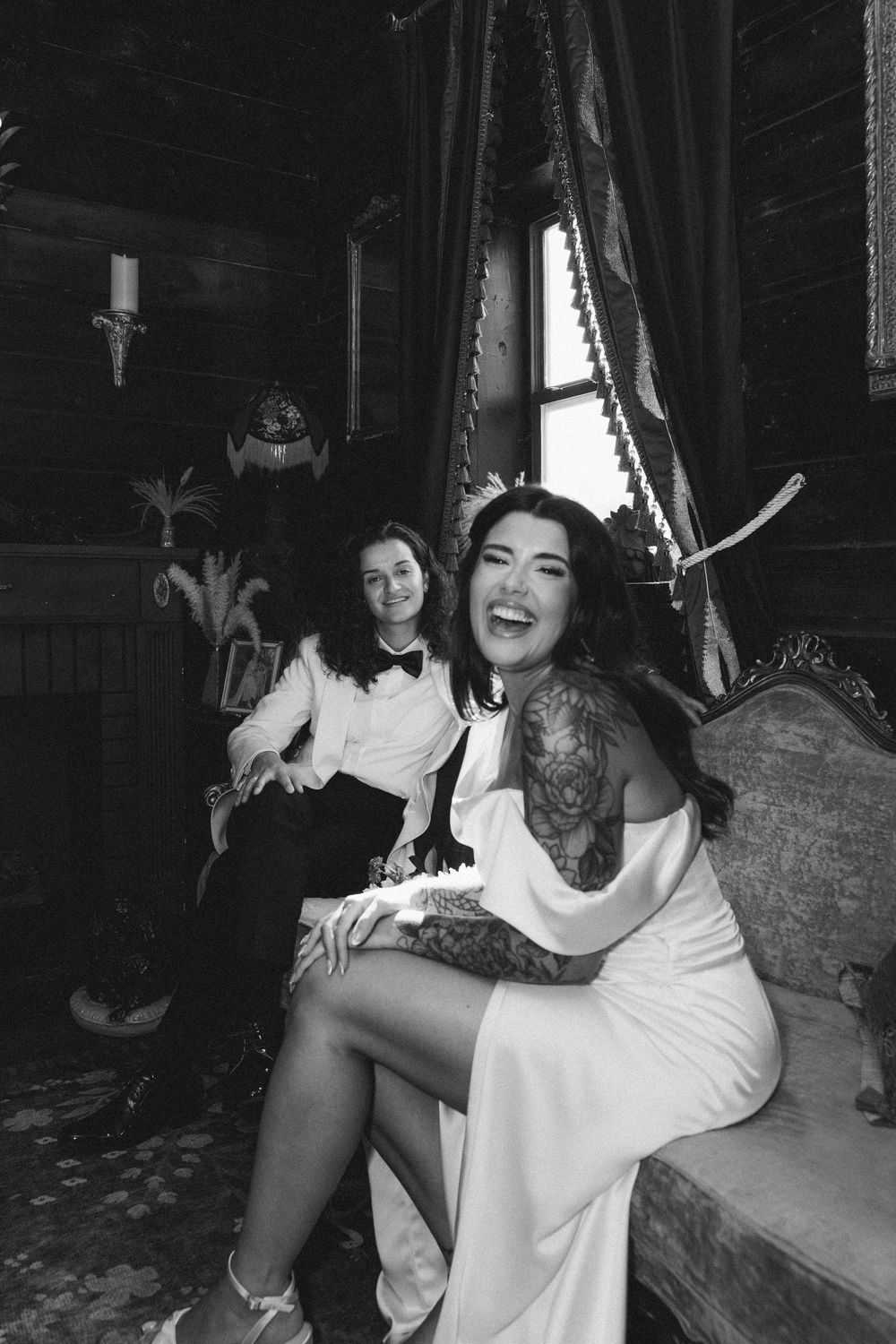 Black and white photo showing joyful laughter and celebration in a dark indoor setting.