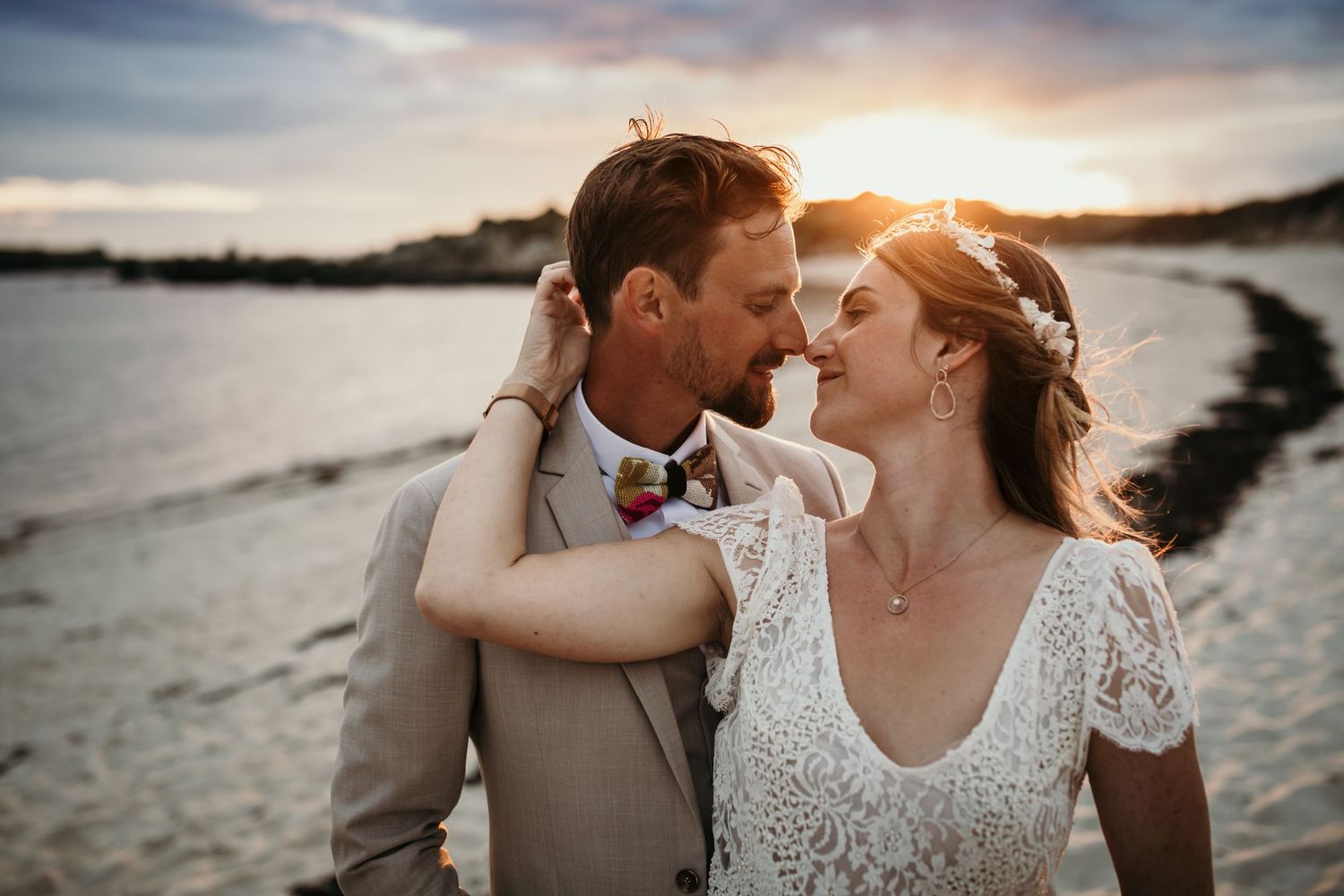 A romantic beachside moment between newlyweds at sunset.