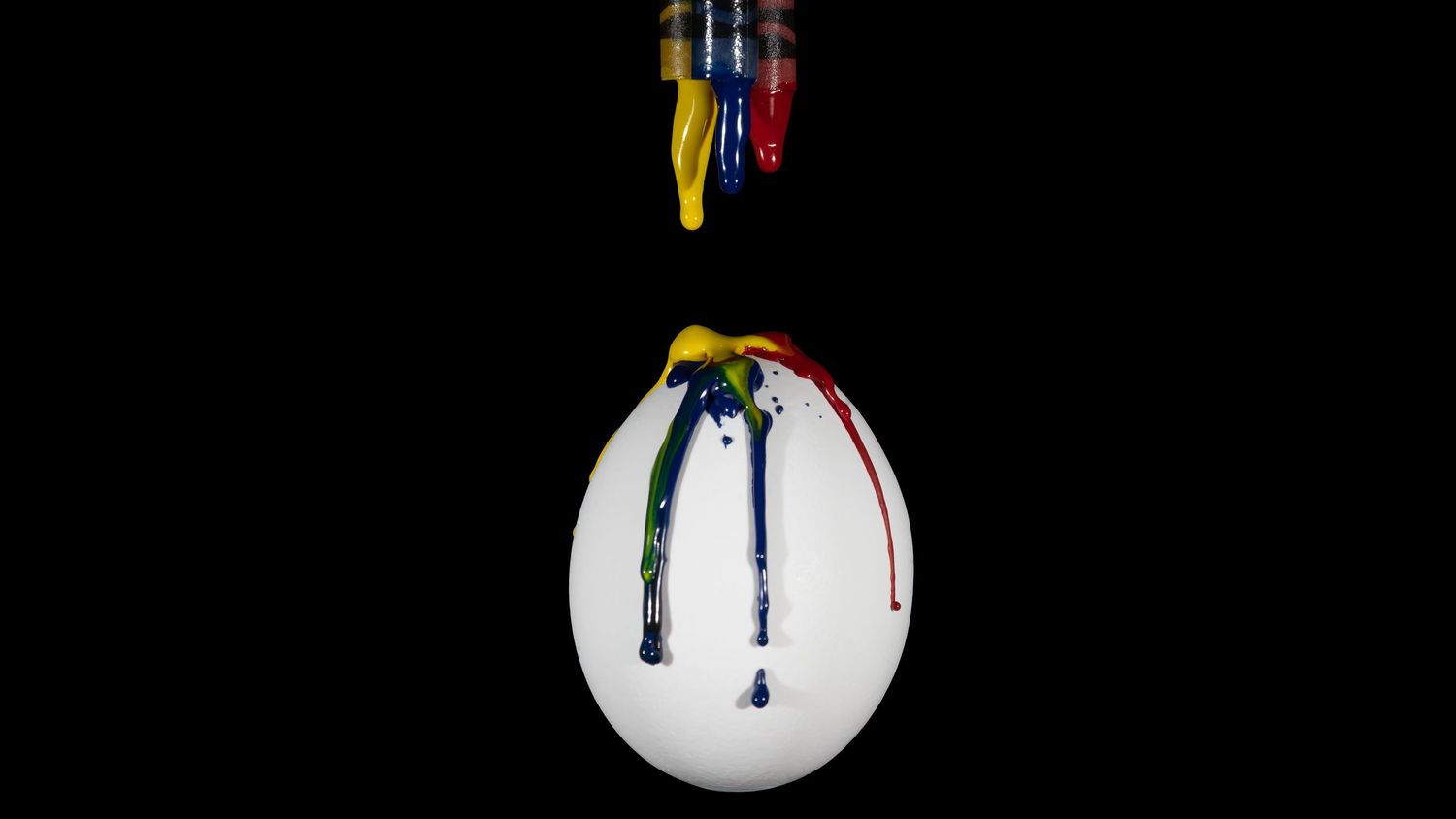 Colorful paint drops falling onto a white egg against a black background creating an artistic composition.