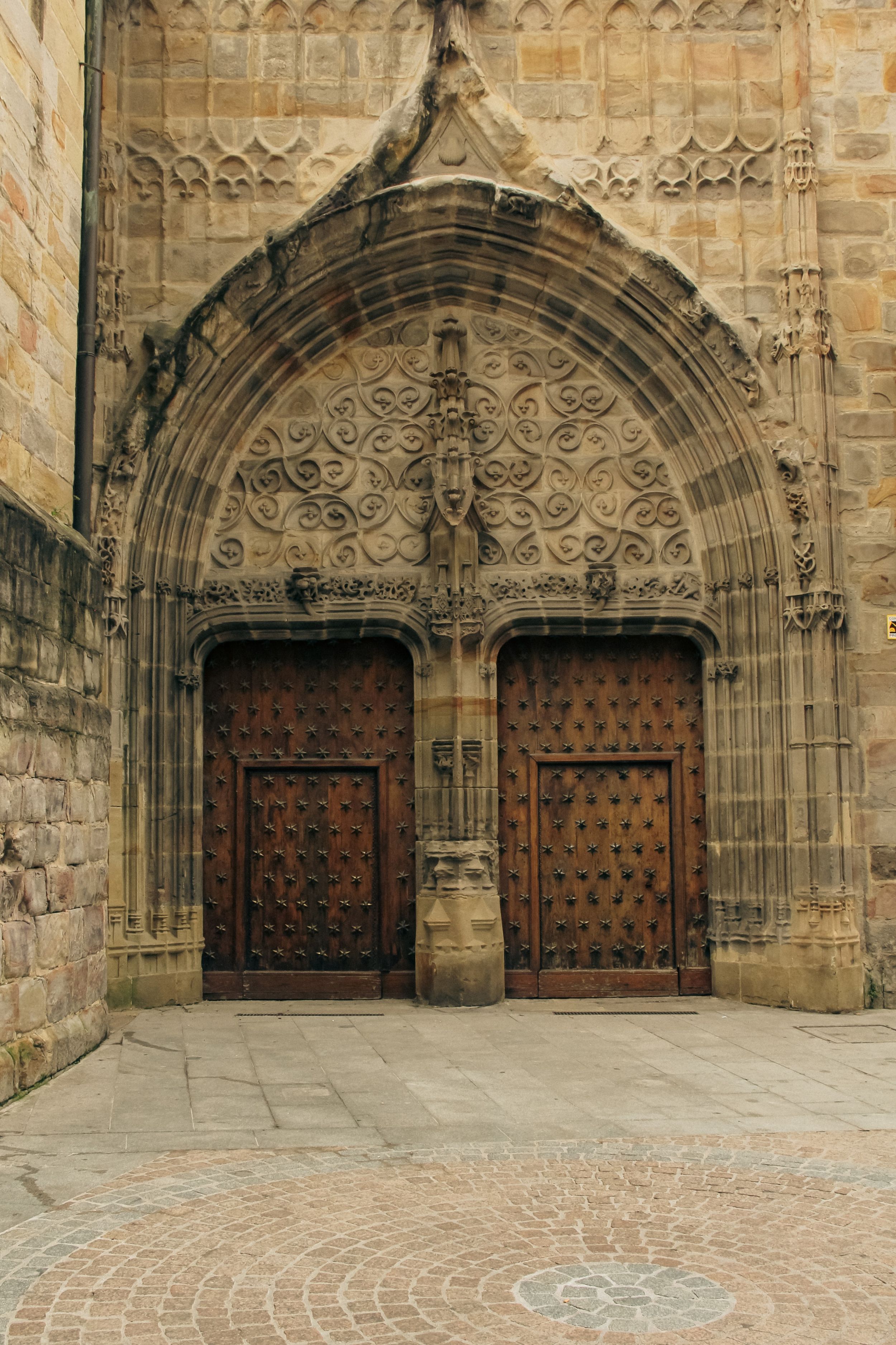 Ancient ornate cathedral doors with detailed stone archway and carved wooden panels.