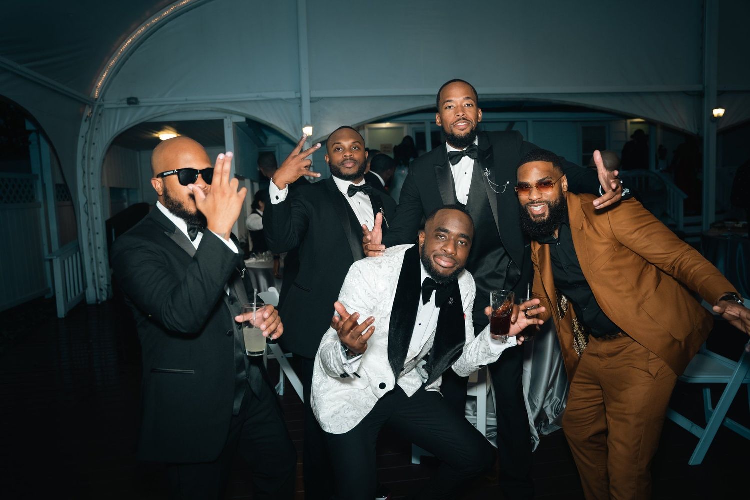 Well-dressed group of friends celebrating at an elegant evening party in formal attire.