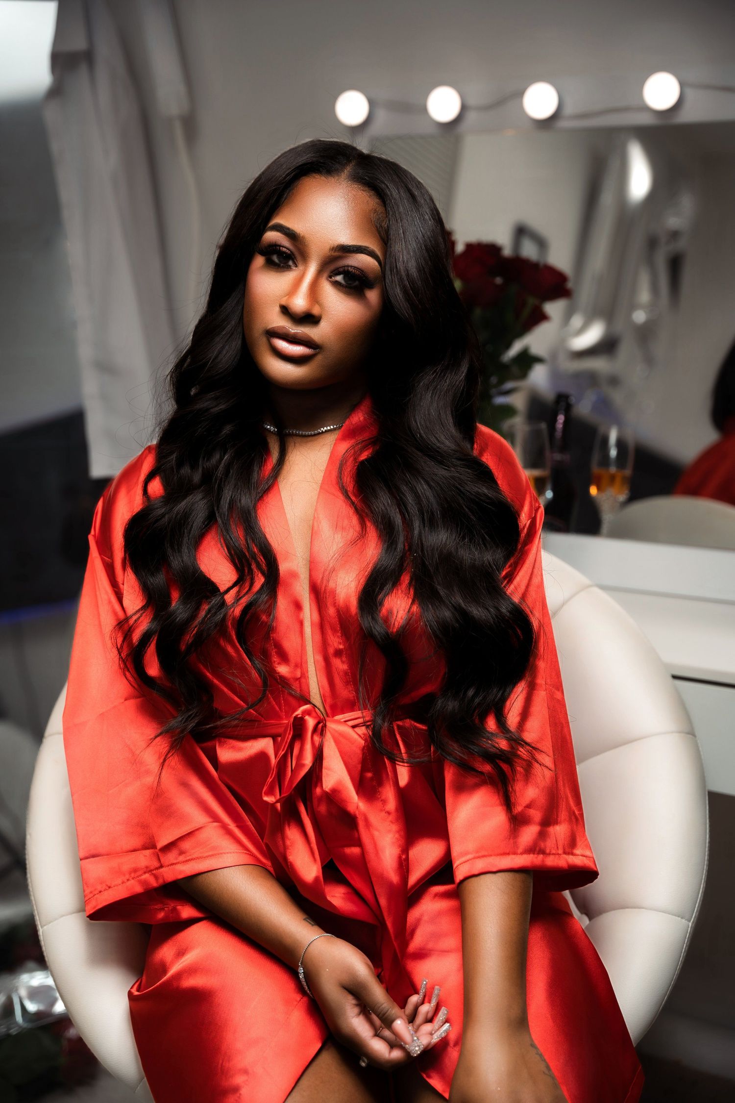 Glamorous portrait in a dressing room featuring a red silk robe and flowing dark hair.