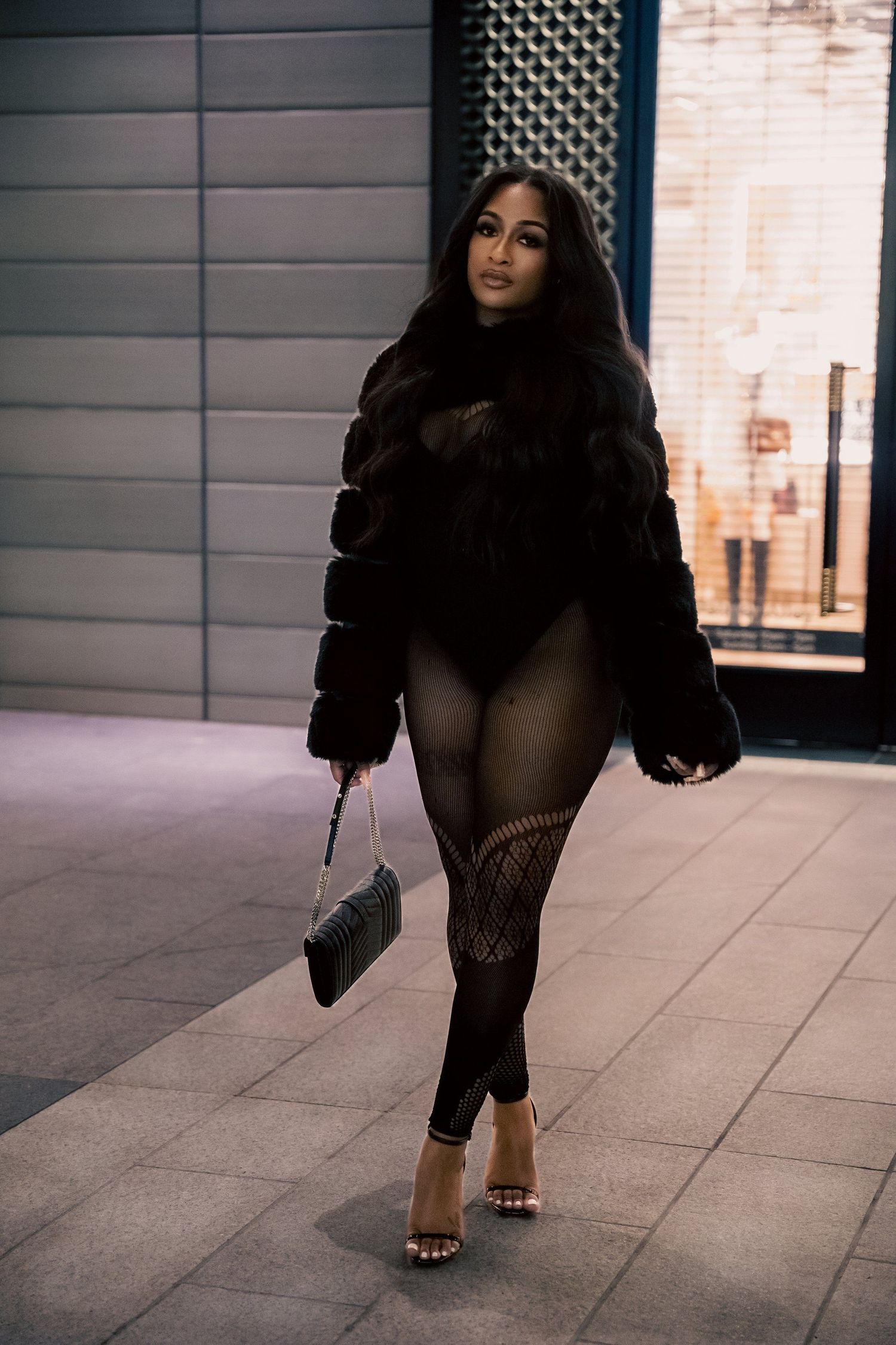 Street style photo of winter fashion with fur coat and designer accessories.