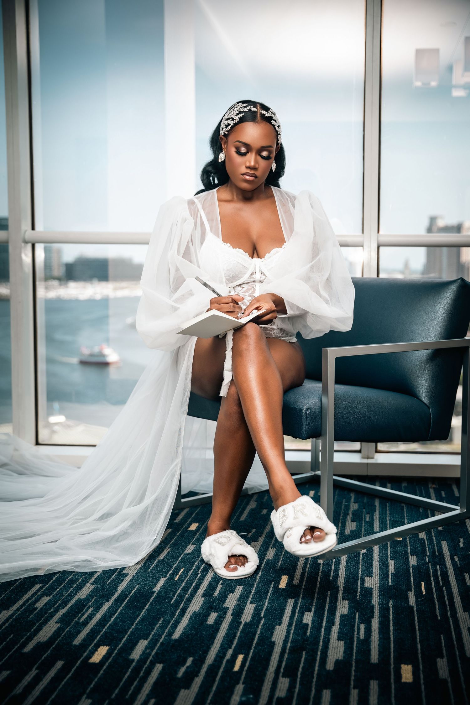 Person in white robe relaxing in hotel room with city view wearing plush slippers.
