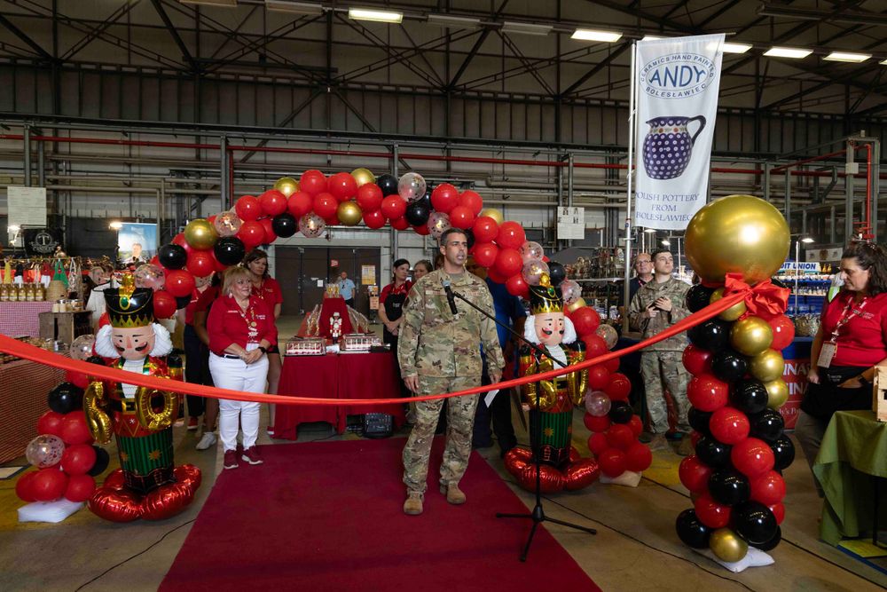Military ceremony setup with red and gold balloon arch and red carpet.