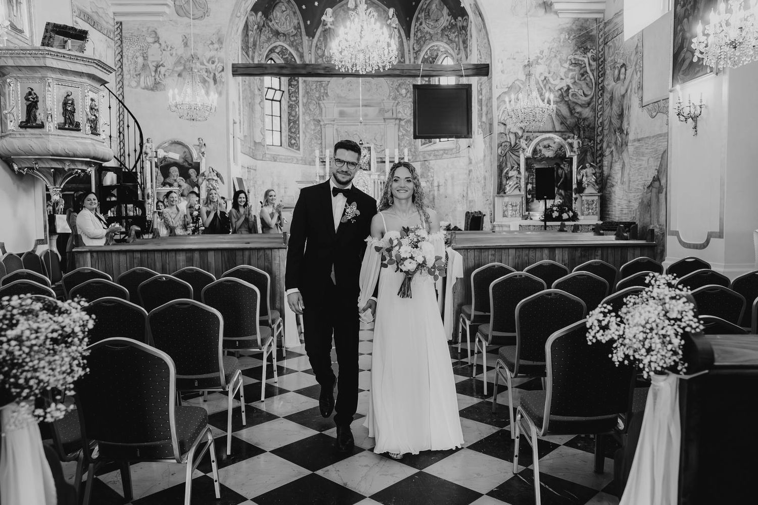 Para młoda wychodzi z kościoła po mszy