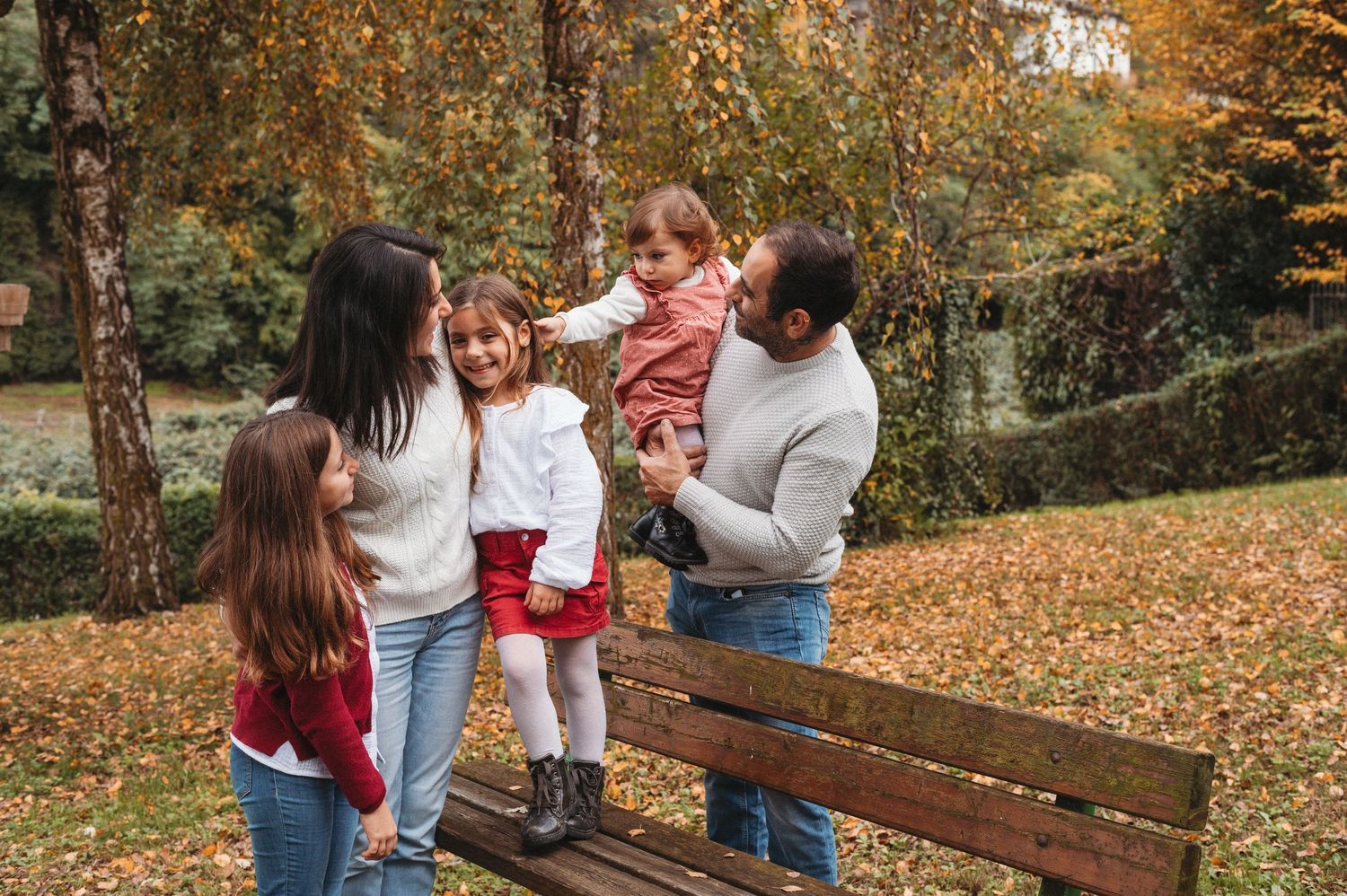 People enjoying a fall day together in a park surrounded by autumn leaves and colorful trees.