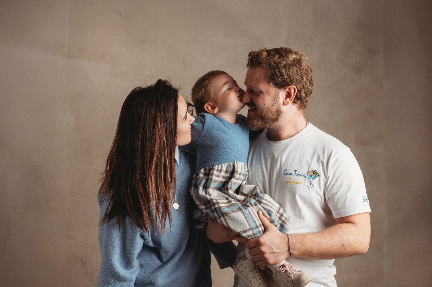 A romantic couple shares intimate moments in a sequence of embrace and kiss photos against a neutral background.