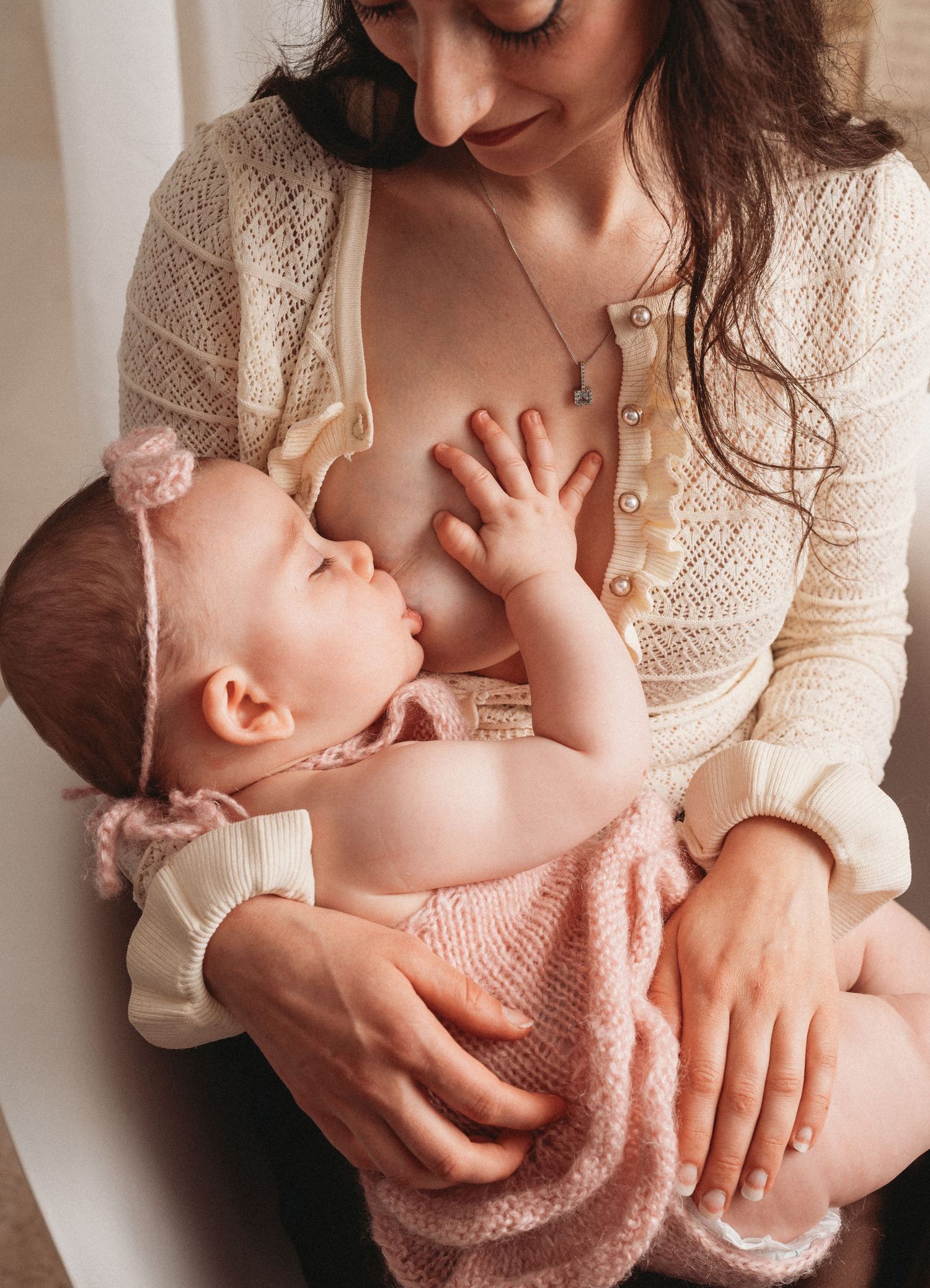 A series of tender moments showing gentle interaction with a baby wearing a pink sweater.
