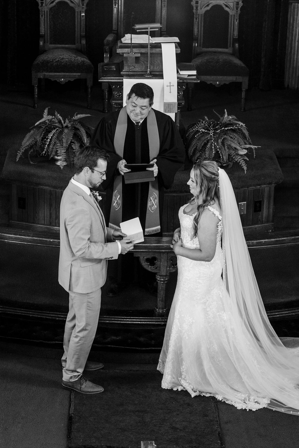 A black and white photo series showing first look moments between a bride and groom in a church setting.