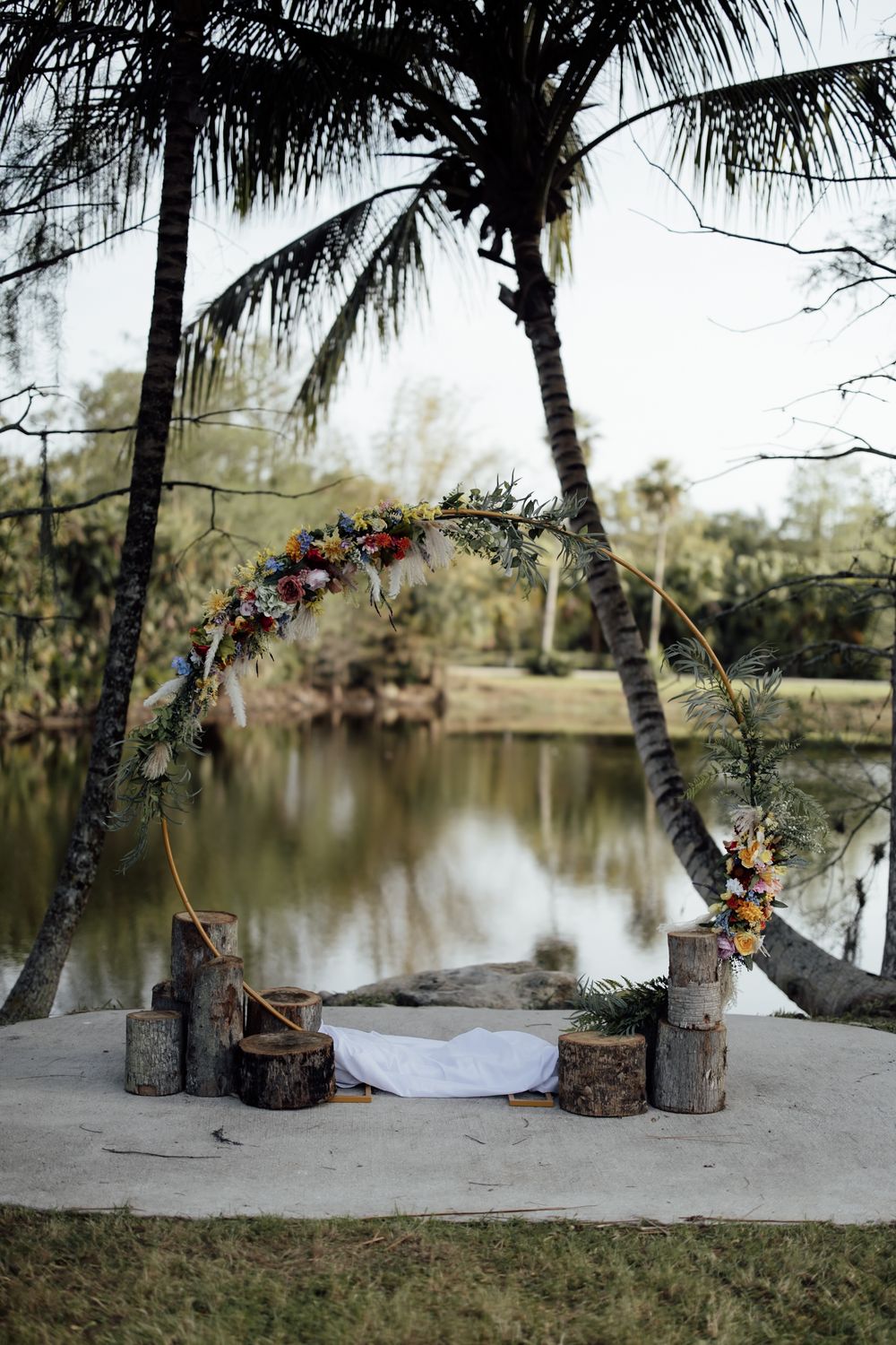 A tranquil scene by a lake with palm trees and wedding decor displayed in progression across five connected photos.