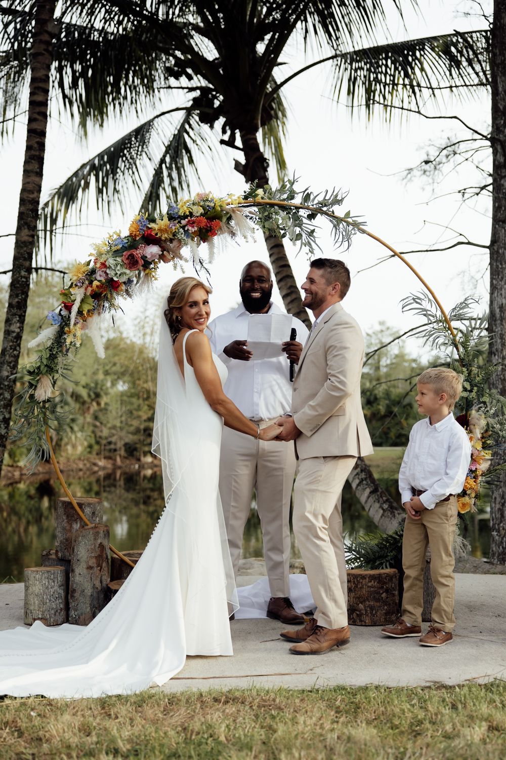 A wedding ceremony sequence showing a small intimate outdoor celebration with palm trees and natural decor.
