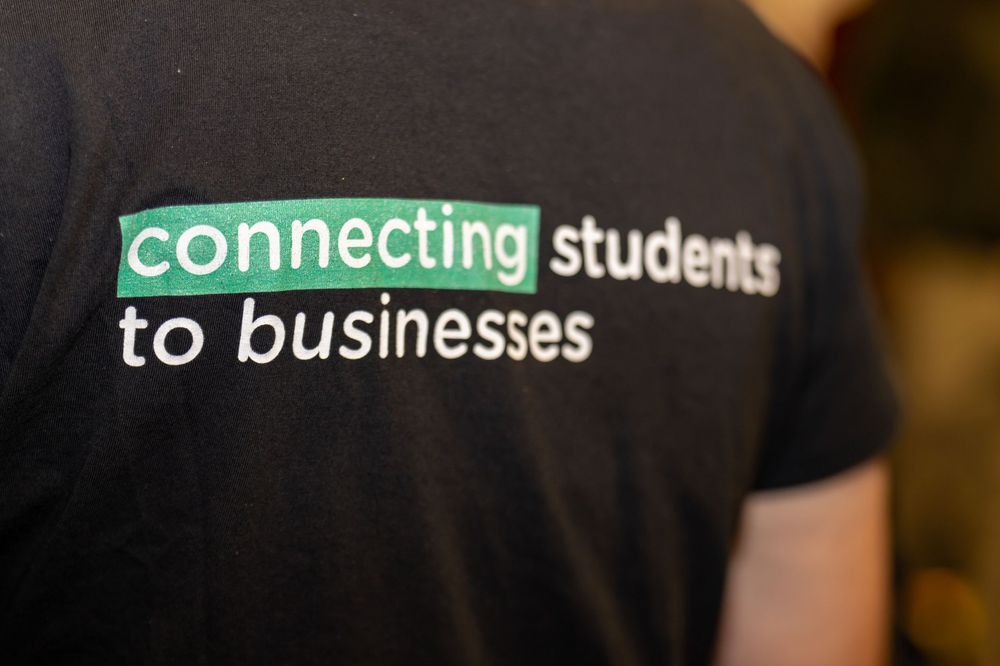 Back of T-shirt reading “connecting students to business” at a careers event.