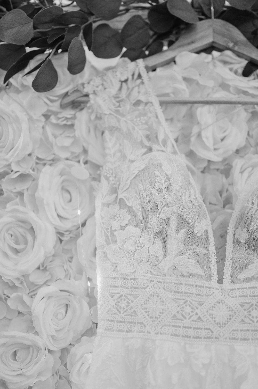 Close-up detail of white lace and rose pattern wedding dress fabric.