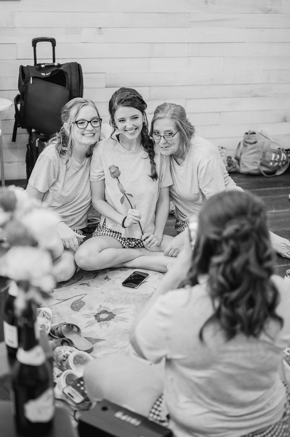Small group engaged in crafting activities around a wooden table in a bright indoor space.