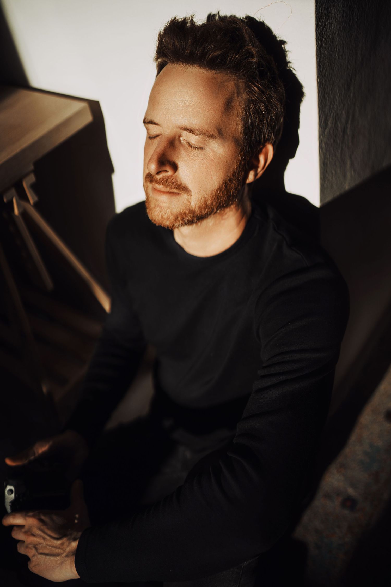 Artistic portrait series with dramatic side lighting against dark background.