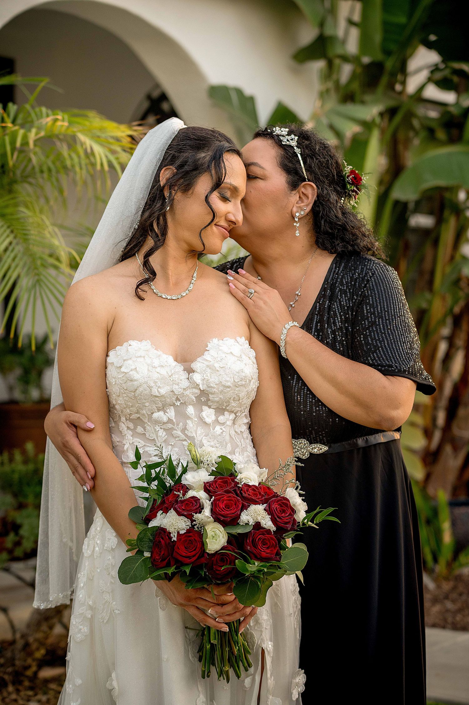 Close-up series showing affectionate moments between two people in wedding attire with red and white bouquet.