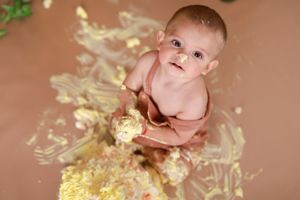 Creative newborn photography with baby surrounded by cream-colored floral elements.