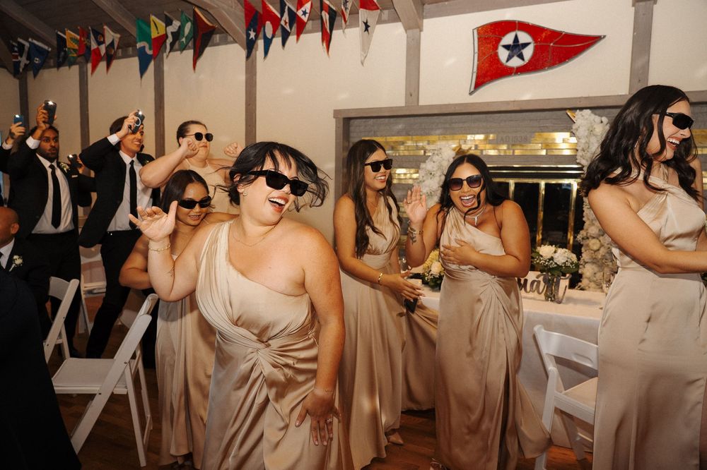 Wedding reception with hanging international flags decorating the ceiling of a bright indoor venue.