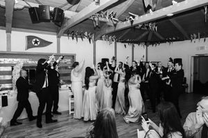 Black and white photo of couples dancing together at a vintage celebration in a decorated indoor venue.