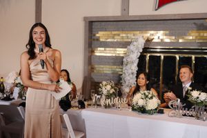 Wedding reception venue with elegant table settings, floral centerpieces and festive decorations.