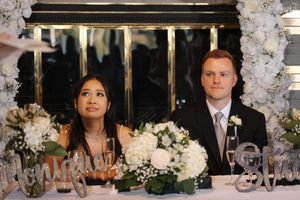 A panoramic view of a wedding reception setting with white floral arrangements and crystal decor at an elegant venue.