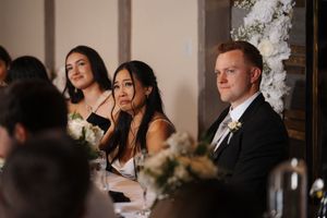 Wedding party enjoying a candid moment with drinks and laughter during a reception celebration.