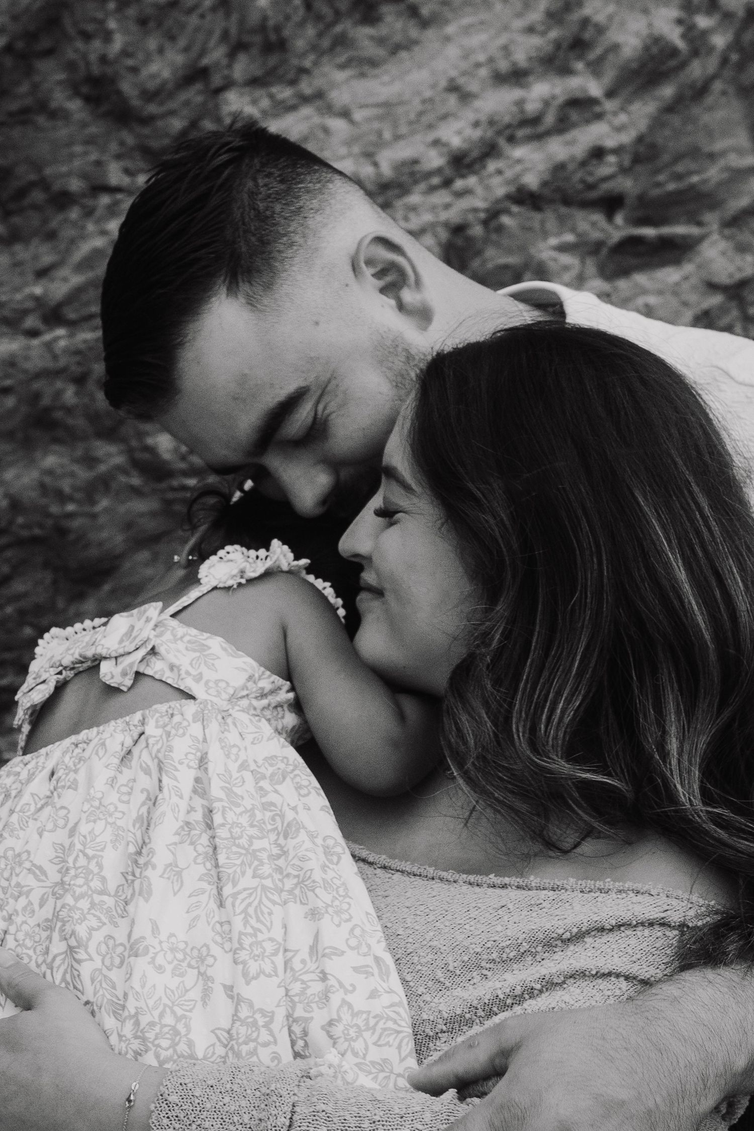 Black and white intimate family moment with baby in lace dress.