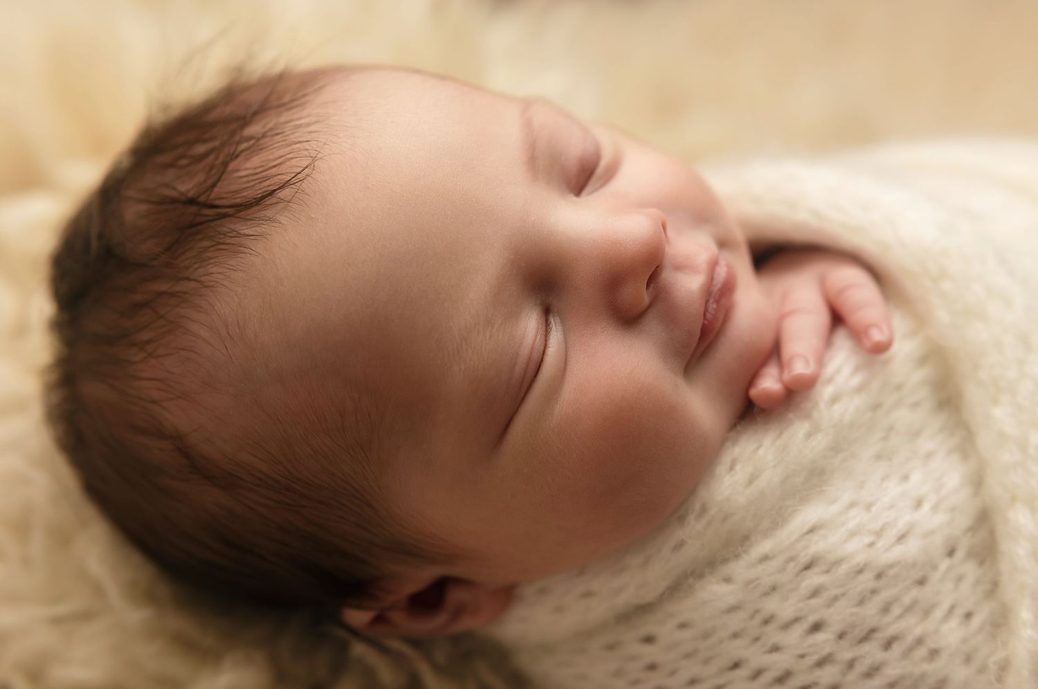 Charlottesville baby smiles in a warm macro shot showing tiny eyelashes in fine detail, captured by Somerset Portraits newborn photographer.