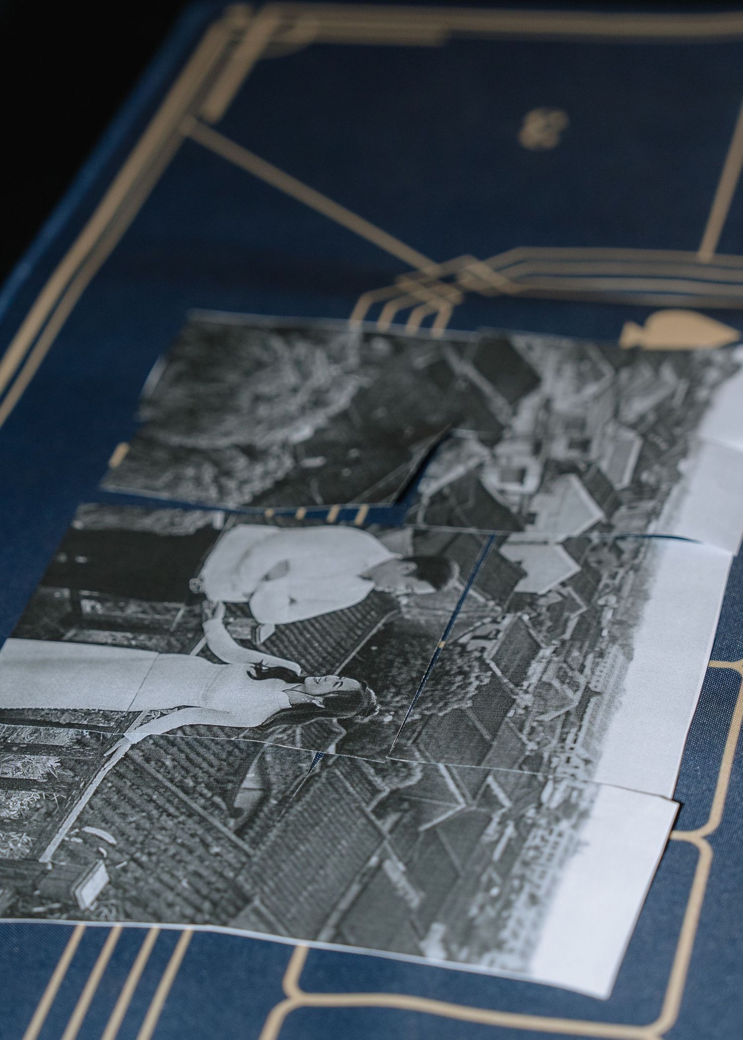 Close-up of black and white vintage photograph placed on an ornate navy and gold decorated wedding game board.