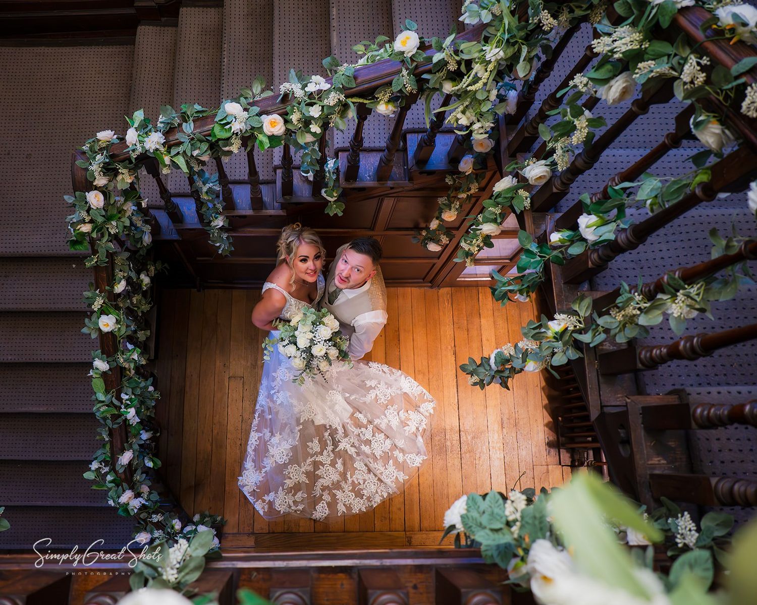 Rothley Court Hotel wedding photographer capturing newlyweds with cascading floral arrangements in historic manor house