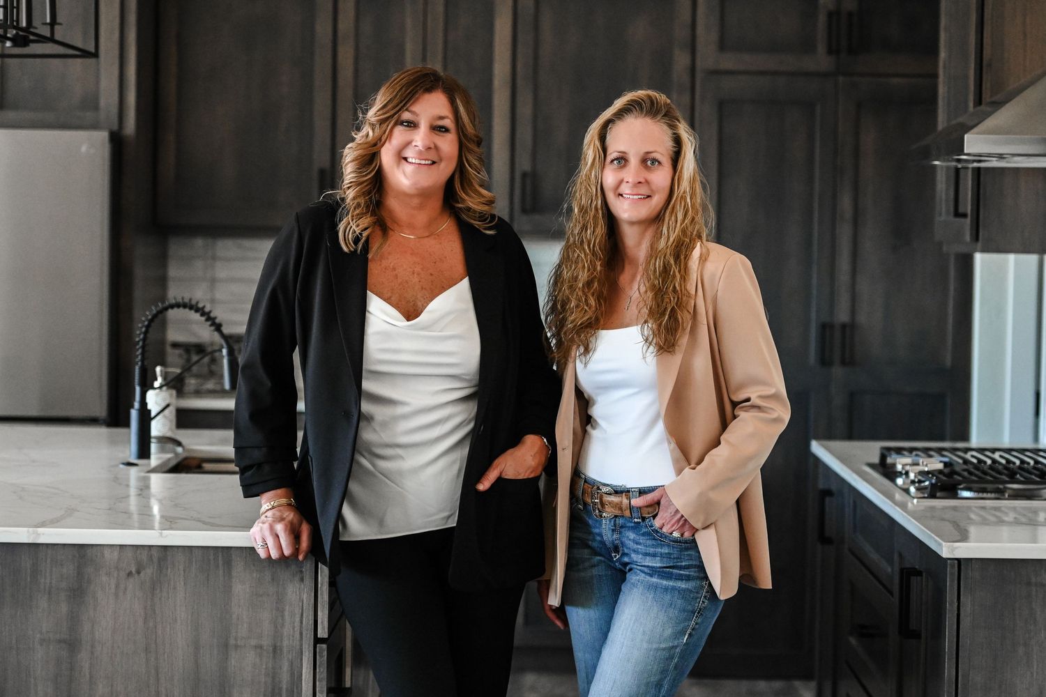 Business professionals laughing together in modern office kitchen space.