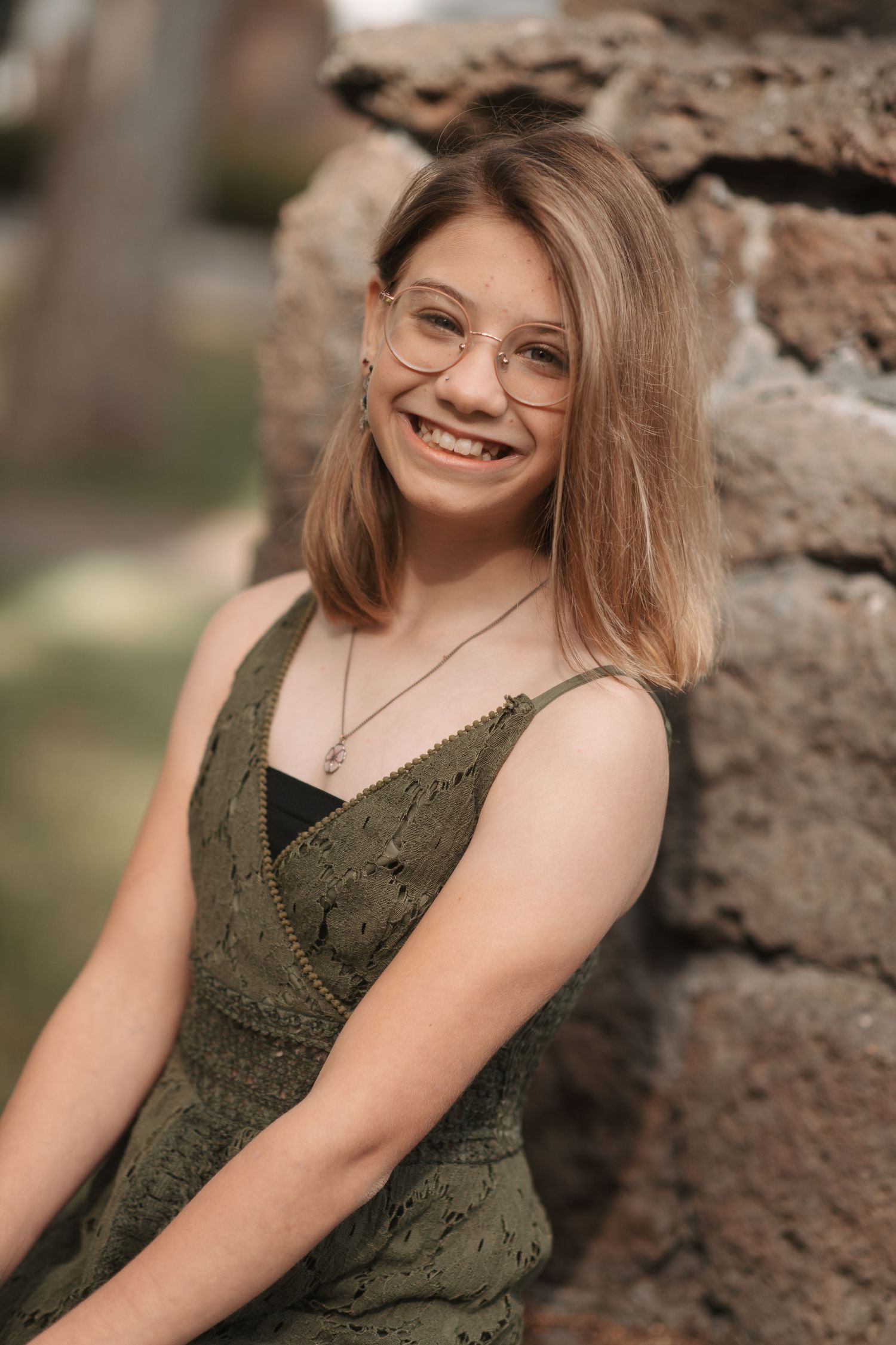 Young girl with glasses smiling during her fall family photography session at Manito Park in Spokane, Washington.