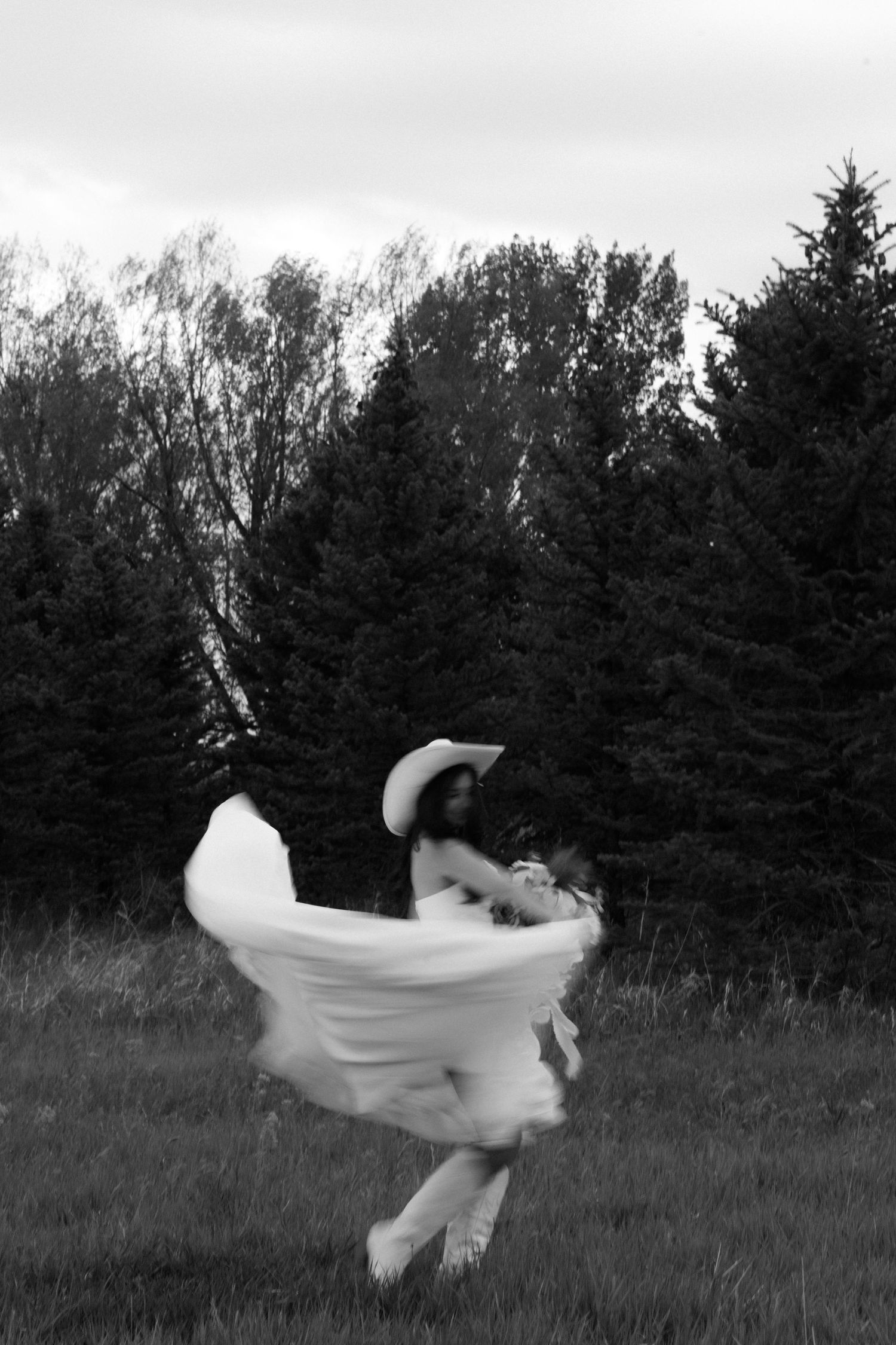 Artistic black and white sequence showing wedding dress twirling in an ethereal outdoor dance.