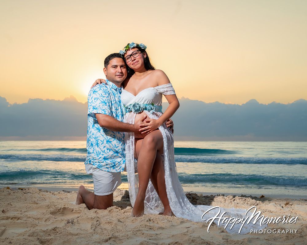 Couple poses romantically on beach at sunset during a maternity photography session by Happy Memories Photography.