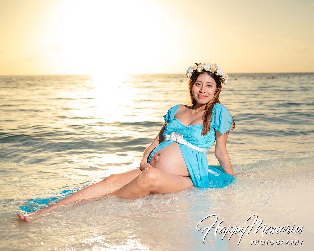 Beach maternity session with turquoise dress during golden hour.