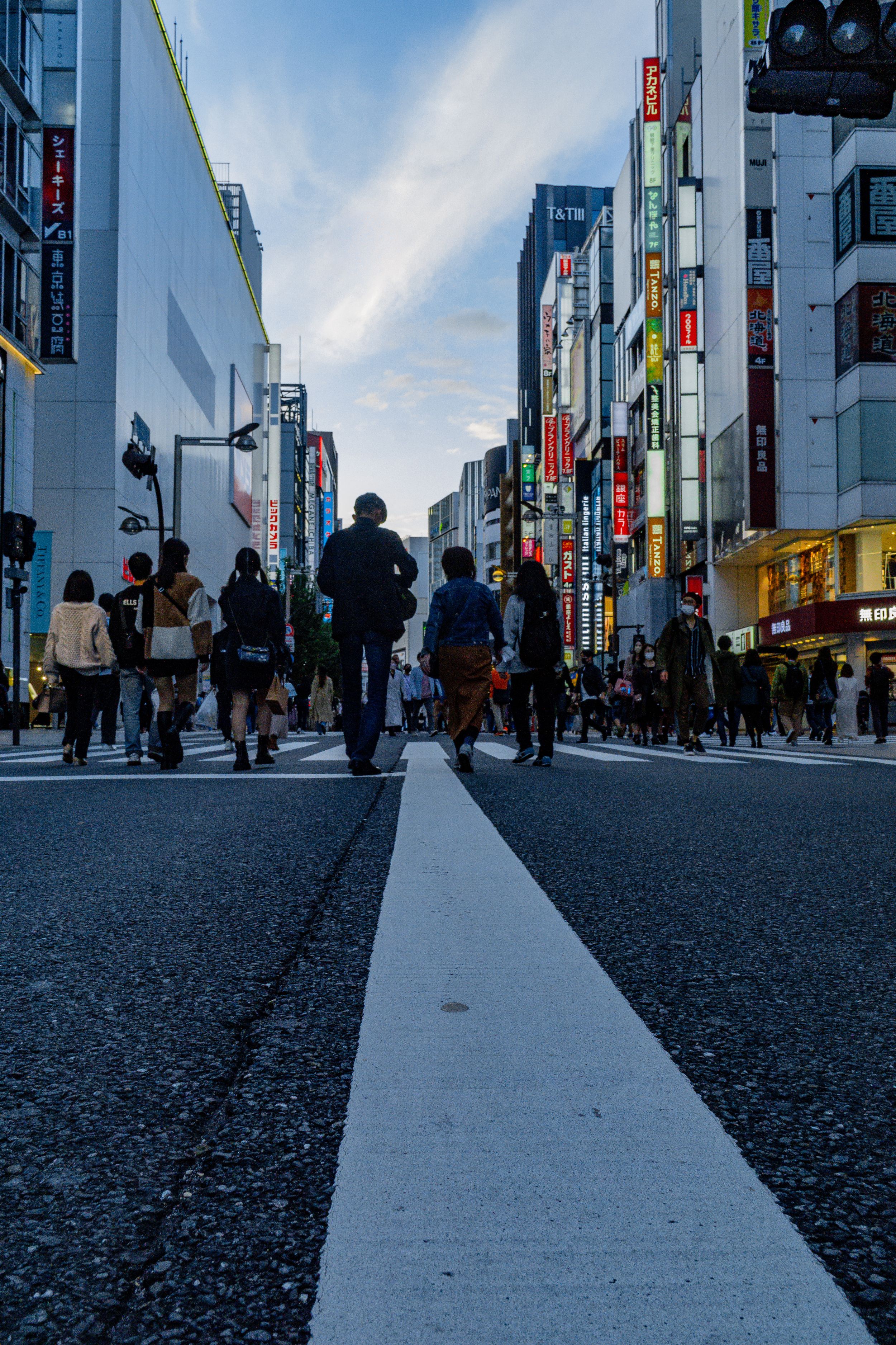 A sequence of progressively emptier city street views in Tokyo showing diminishing crowds on the sidewalk and buildings.