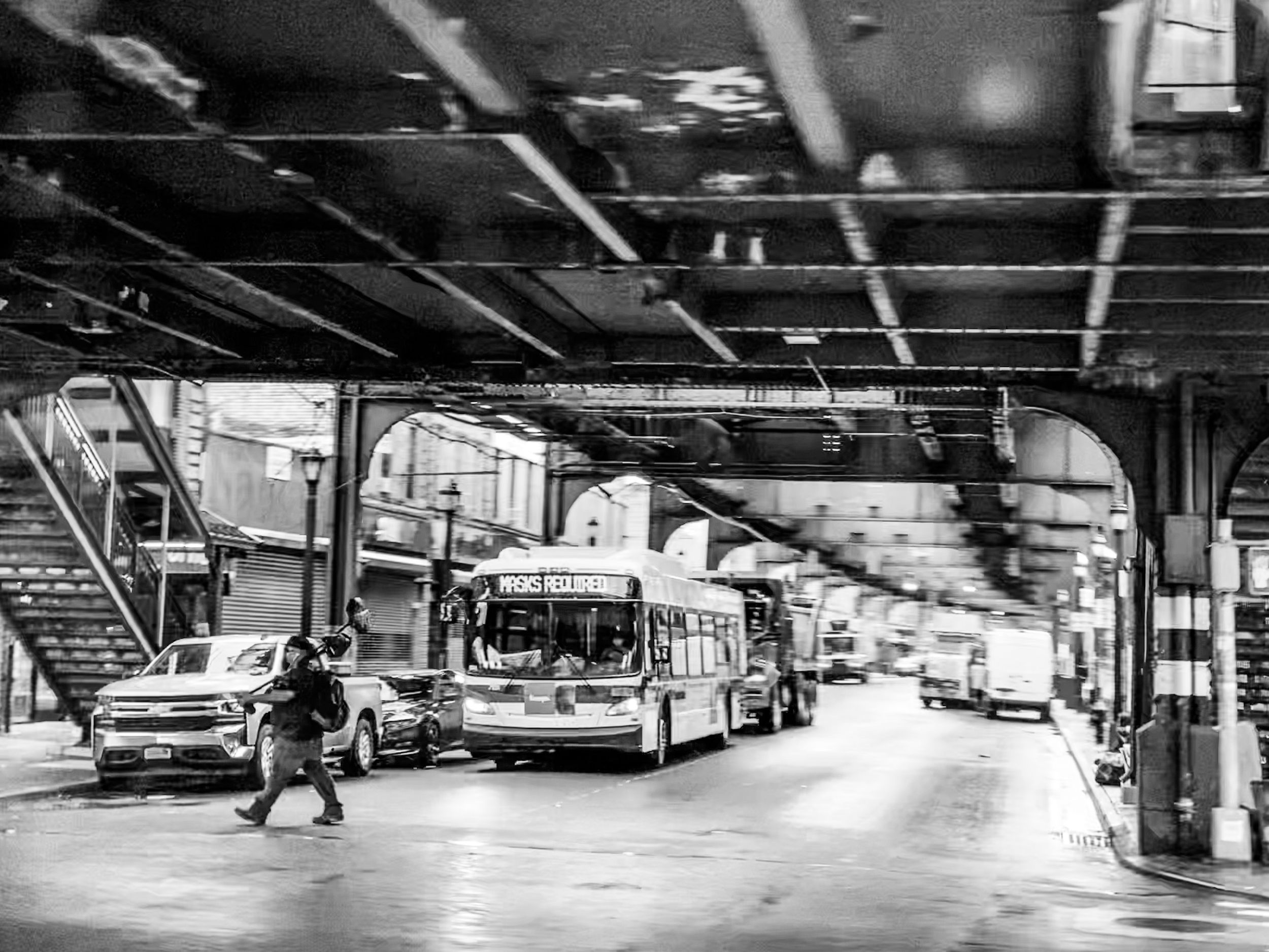 A dramatic black and white aerial view of parked passenger buses inside a large maintenance depot.