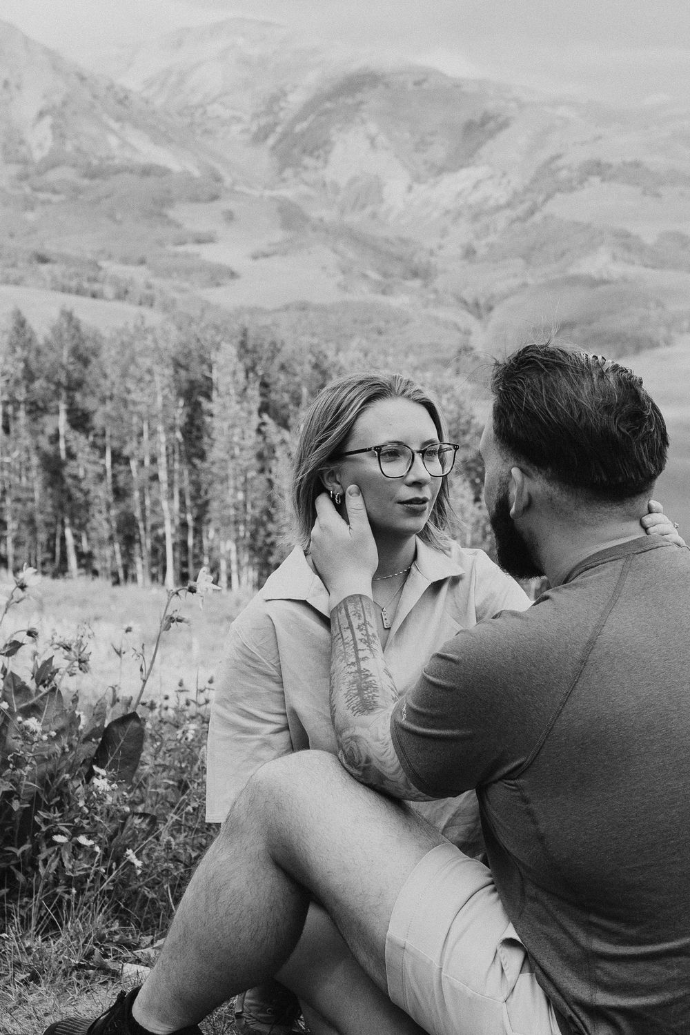A series of vintage black and white photographs showing a couple embracing outdoors with mountains in the background.