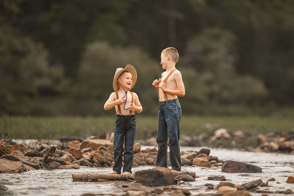 Young couple in casual wear walking along rocky outdoor terrain while engaged in conversation.