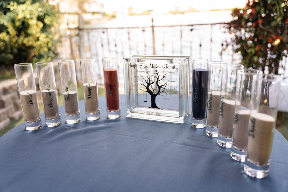 A sequence of seven transparent glass vases arranged on a windowsill with a bright natural outdoor backdrop.