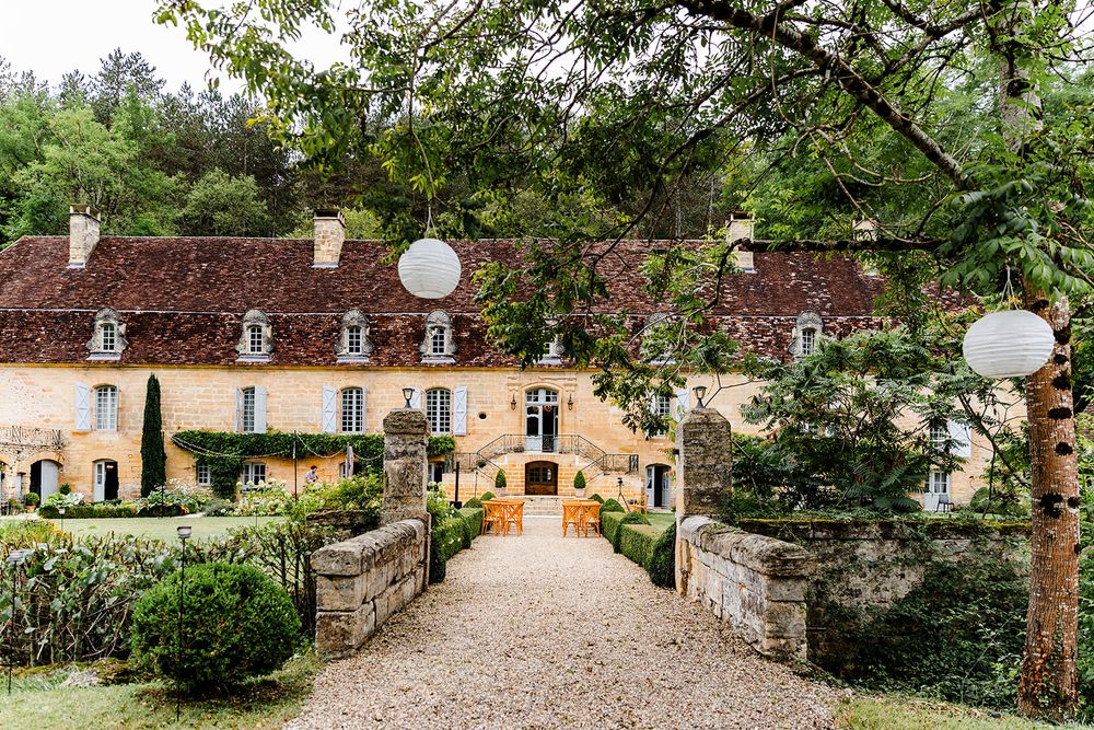 Elegant French chateau entrance with stone pathway and decorative garden lanterns.