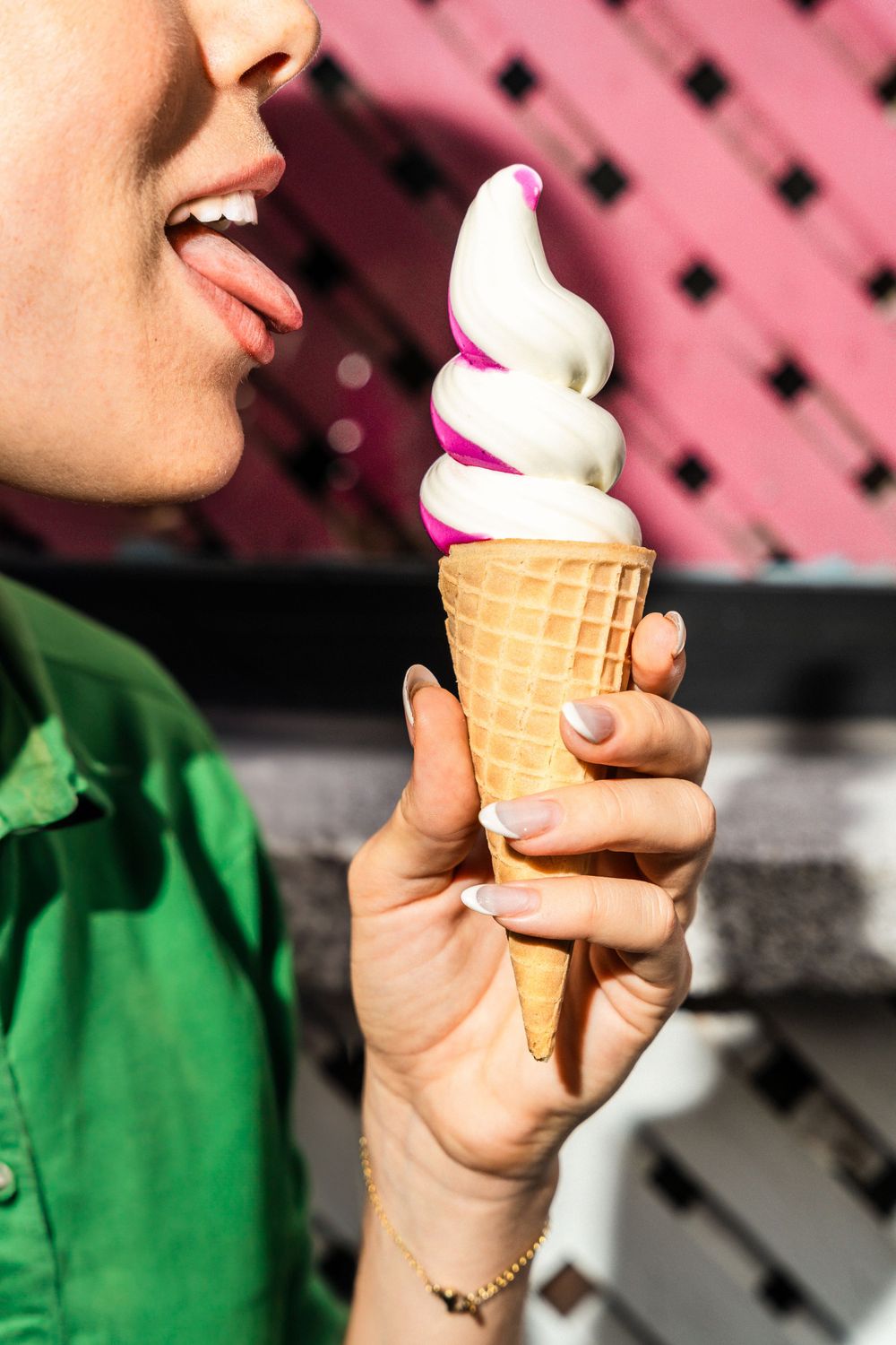 Close-up of soft serve ice cream cone with pink and white swirls against pink background. Mtlshutter photography