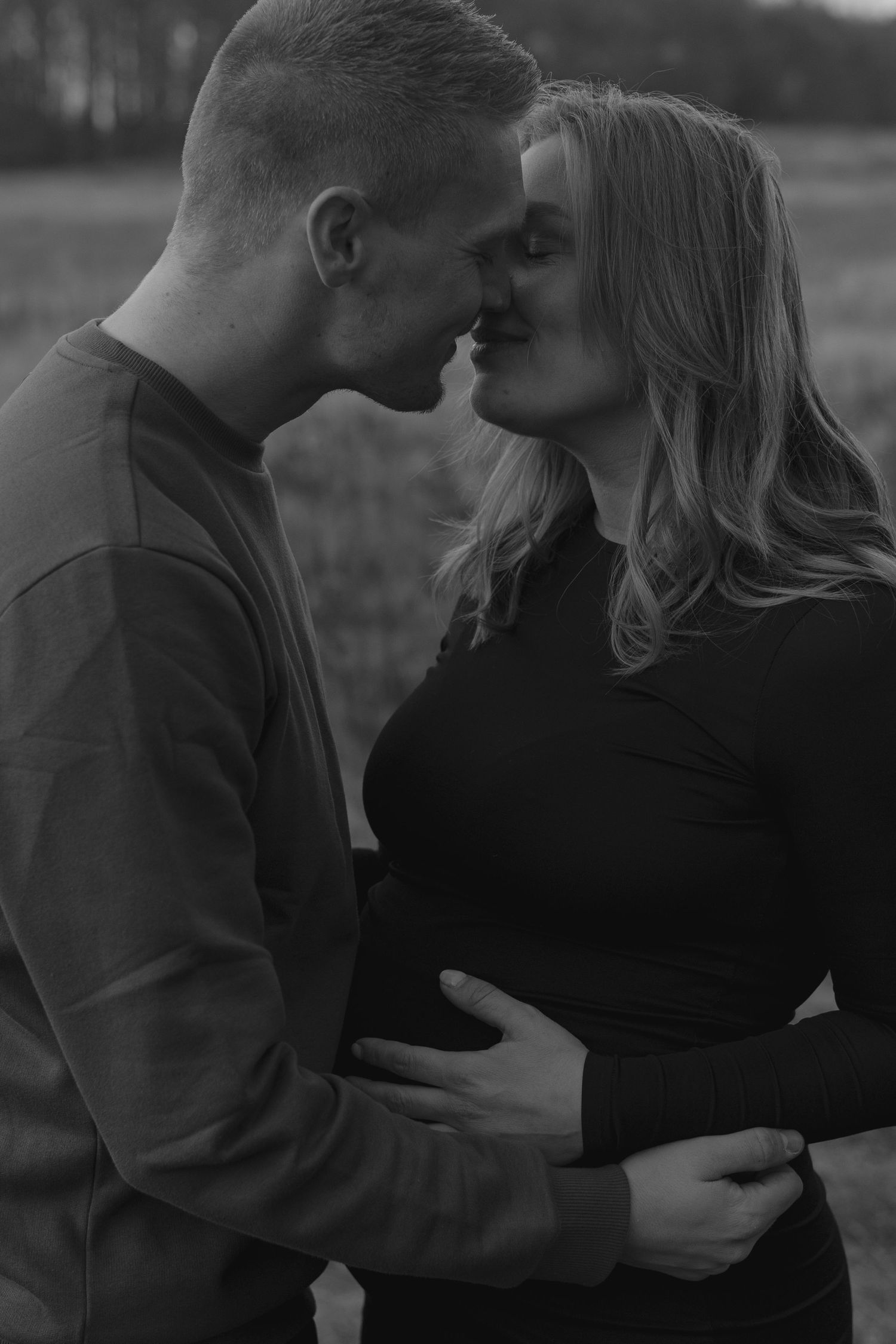 Black and white intimate maternity portrait outdoors.