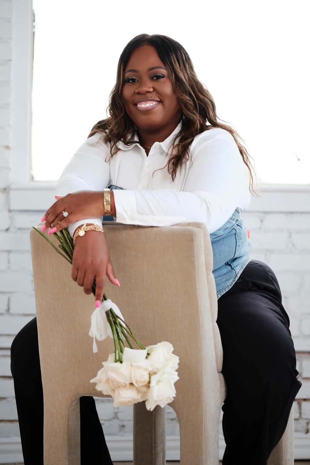 Professional portraits with white flowers against brick wall background.