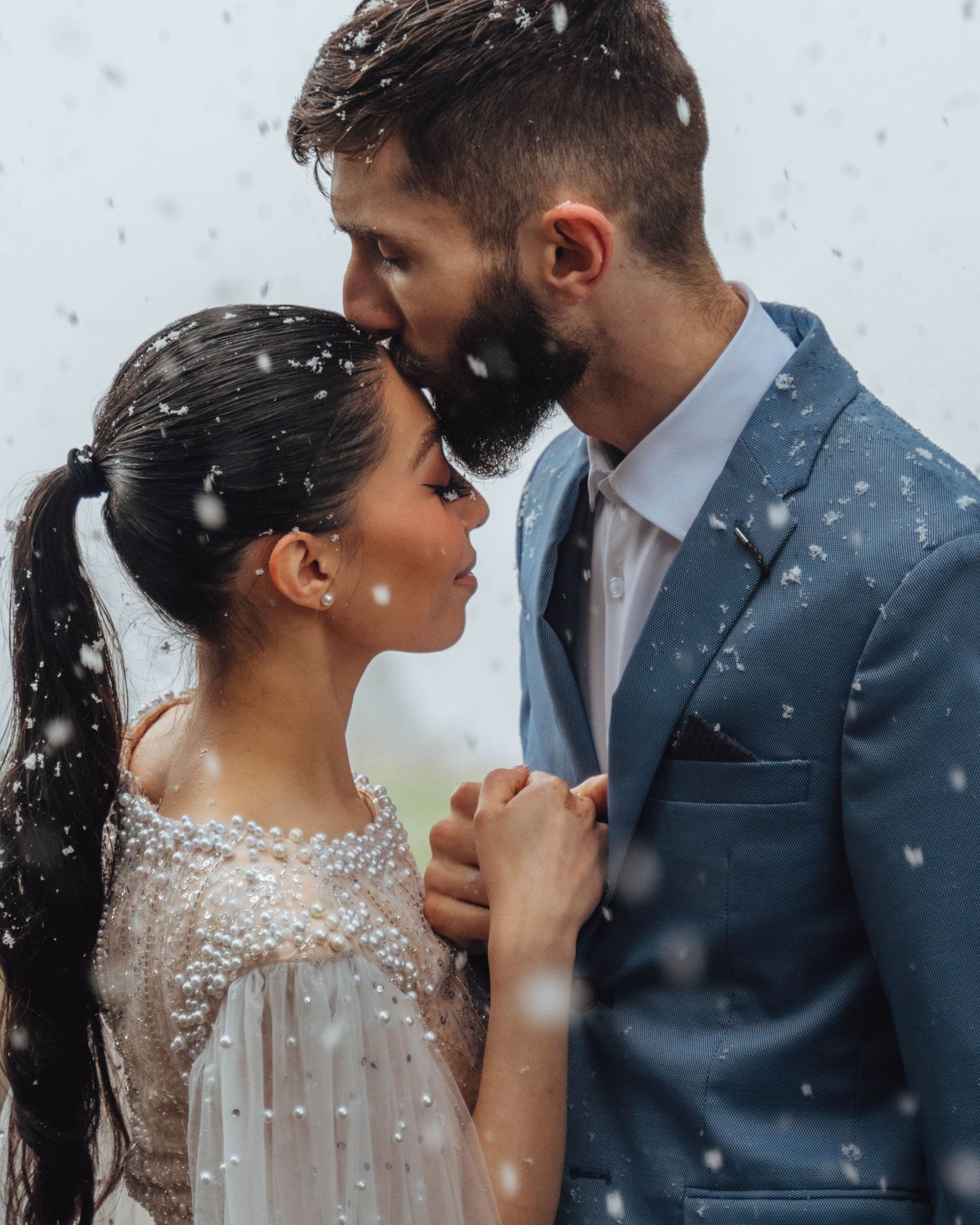 Groom kisses bride in the snow. Banff winter wedding.